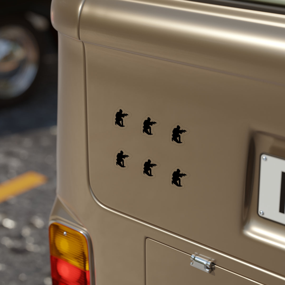 A close-up of a beige vehicle tailgate featuring six black vinyl decals of soldier silhouettes arranged in two columns of three.